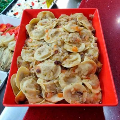 Pasta fresca rellena de berenjena con tomate casse, pasas y piñones